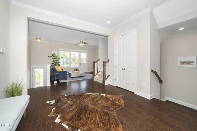 a living room with furniture and a dining table with wooden floor