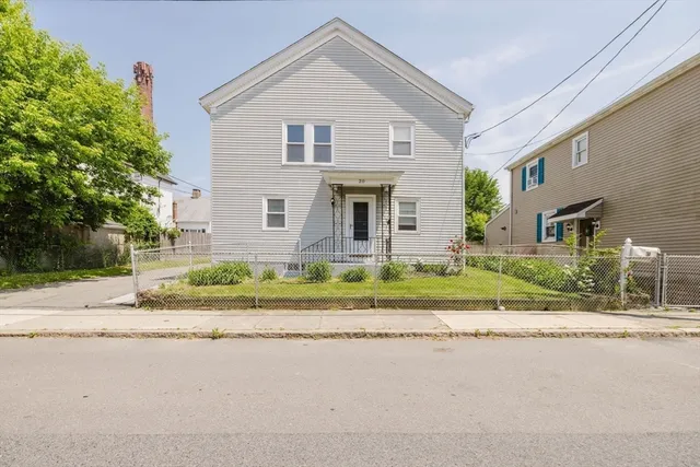 a front view of house with a garden and plants