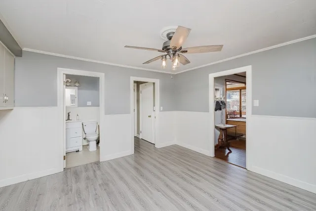 a kitchen with granite countertop a stove a sink and white cabinets with wooden floor
