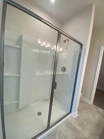 a bathroom with a glass shower door and a sink