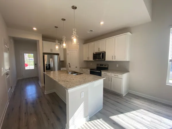 a kitchen with a sink a microwave and cabinets