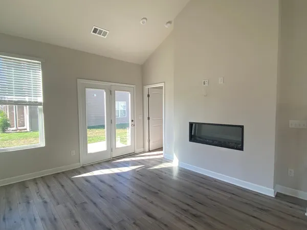 an empty room with wooden floor and windows
