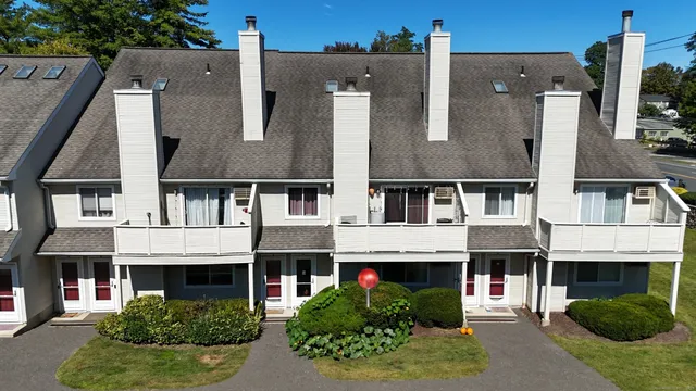 front view of house with a yard and potted plants
