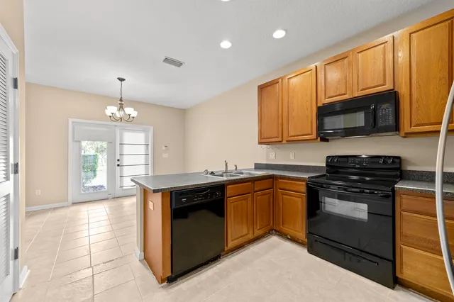 a kitchen with stainless steel appliances granite countertop wooden cabinets a stove top oven a sink and dishwasher