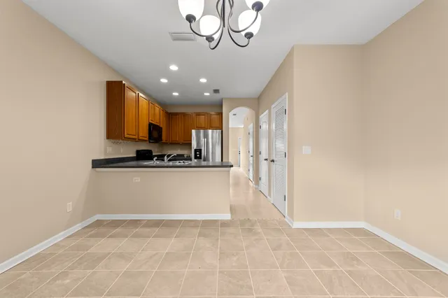 a view of kitchen with granite countertop cabinets and refrigerator