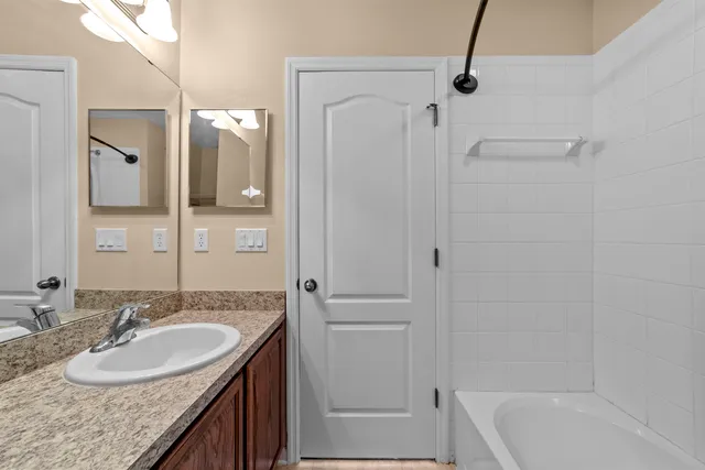 a bathroom with a granite countertop sink and a mirror