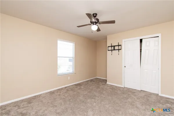 a view of a big room with windows and chandelier fan