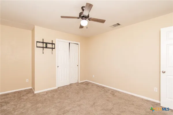 a view of a room with a ceiling fan and wooden floor