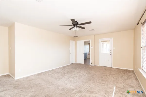 a view of a room with a ceiling fan and a window