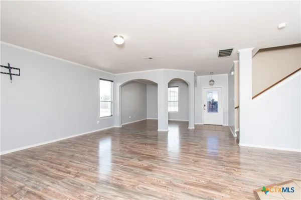 a view of empty room with wooden floor