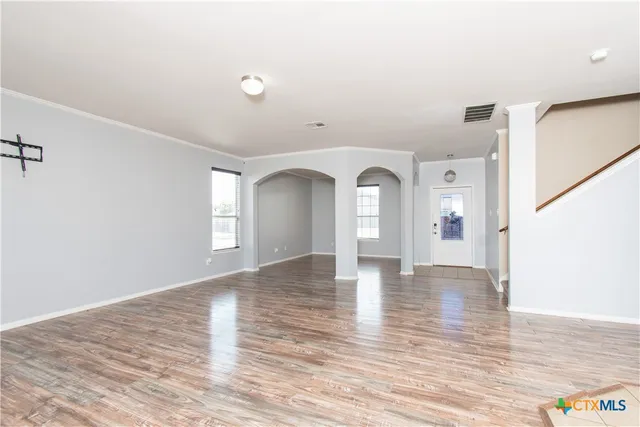 a view of empty room with wooden floor