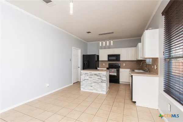 a large white kitchen with cabinets