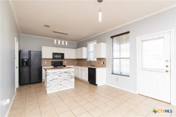 a large kitchen with cabinets and stainless steel appliances