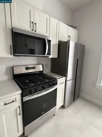a kitchen with stainless steel appliances a stove microwave and refrigerator