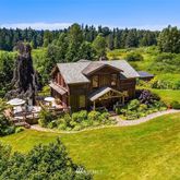 a view of a house with a big yard and sitting area