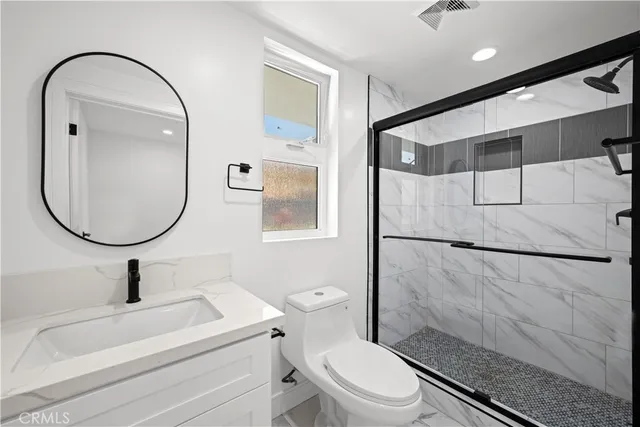 a bathroom with a sink a toilet and a mirror