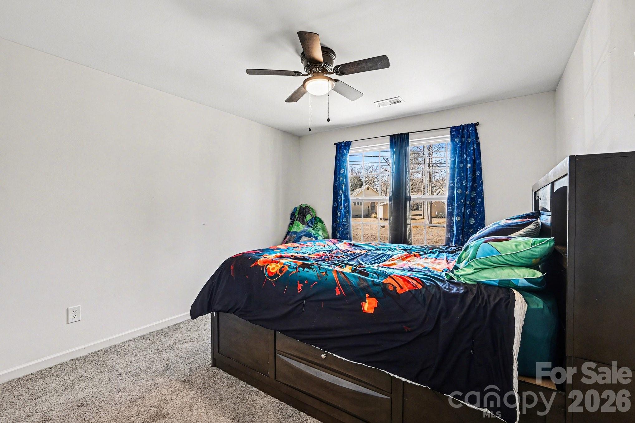 313 Bell Street Mount Holly, NC 28120 - Photo 15 of 19 a bedroom with a bed and a chandelier