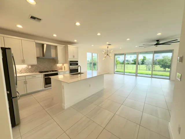 a kitchen with stainless steel appliances granite countertop a refrigerator and a stove top oven