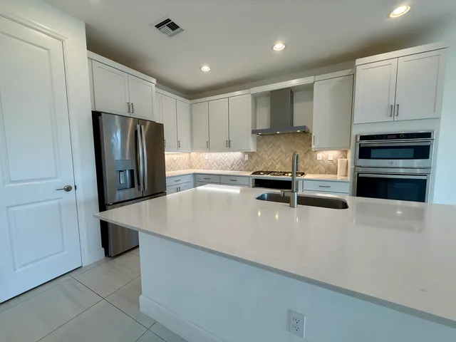 a kitchen with stainless steel appliances a refrigerator sink and stove