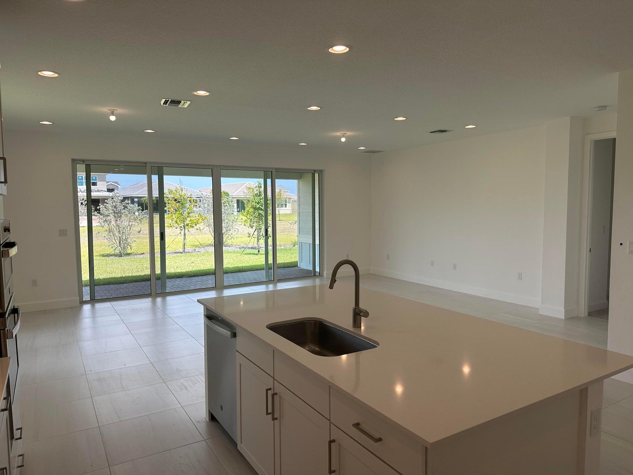1346 Harvester Crossing Loxahatchee, FL 33470 - Photo 14 of 43 a kitchen with counter top a sink and cabinets
