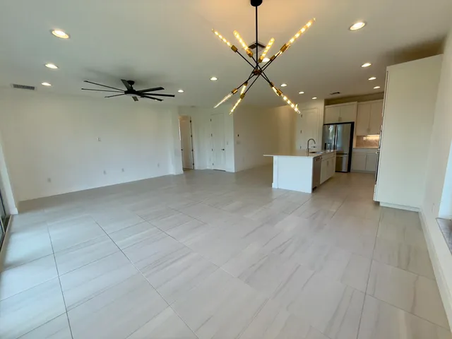an empty room with wooden floor and a ceiling fan