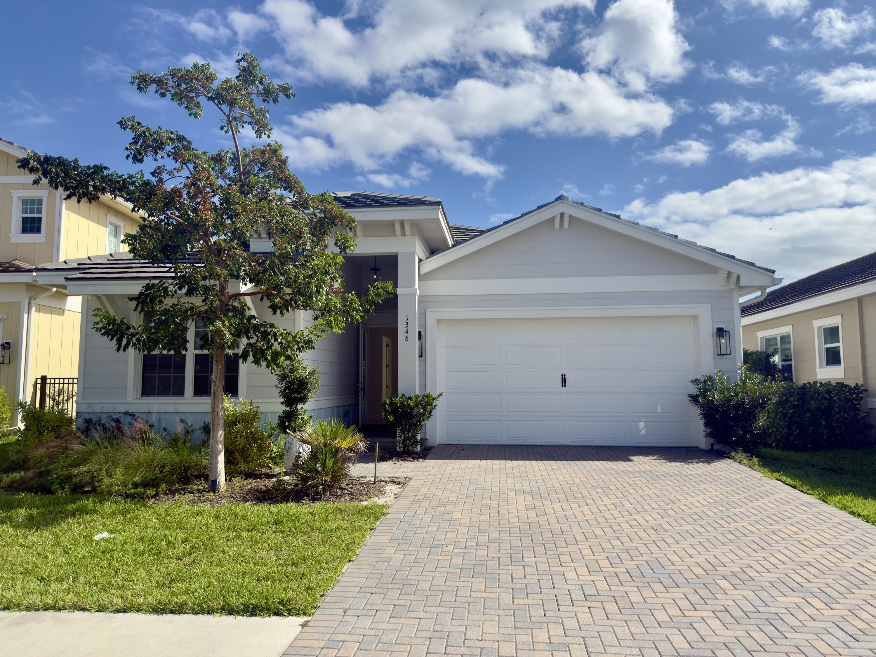 1346 Harvester Crossing Loxahatchee, FL 33470 - Photo 2 of 43 a front view of a house with a garden