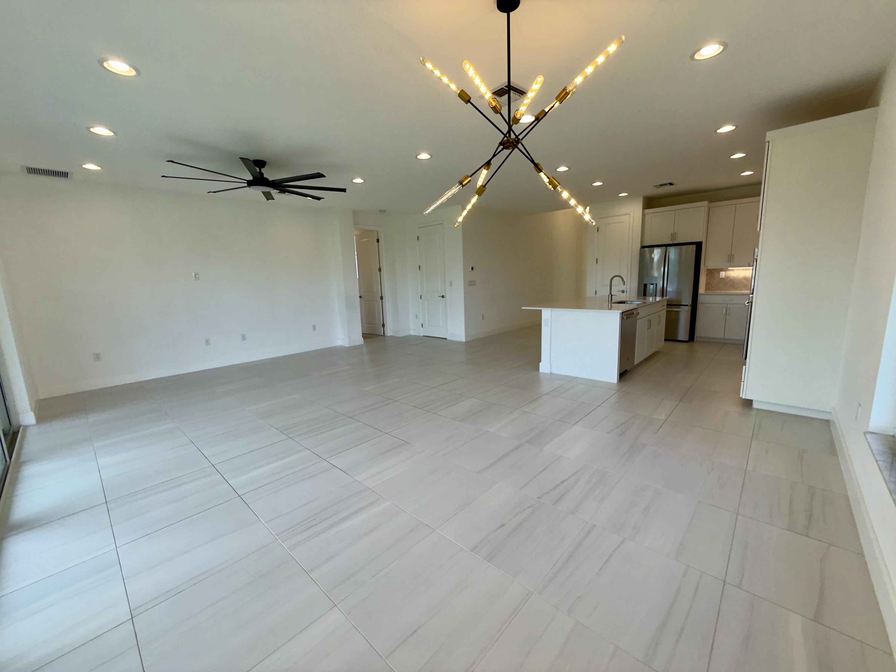 1346 Harvester Crossing Loxahatchee, FL 33470 - Photo 21 of 43 an empty room with wooden floor and a ceiling fan
