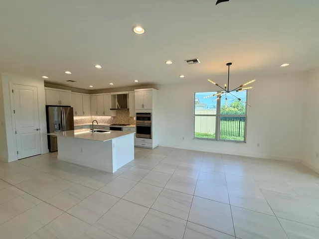 a large kitchen with a large counter top stainless steel appliances and cabinets