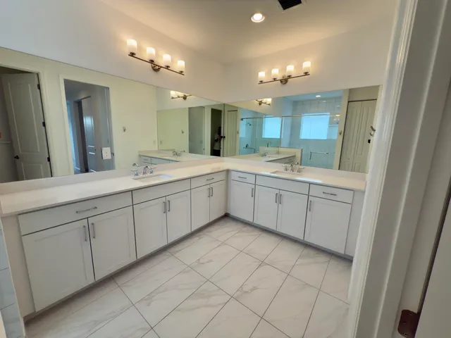a view of a double vanity sink mirror and cabinets