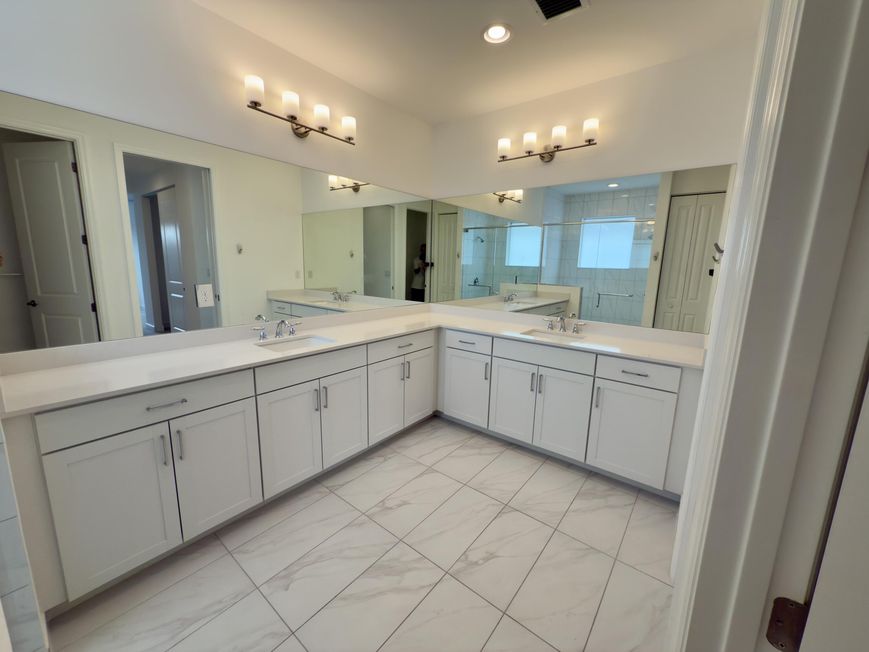 1346 Harvester Crossing Loxahatchee, FL 33470 - Photo 24 of 43 a view of a double vanity sink mirror and cabinets