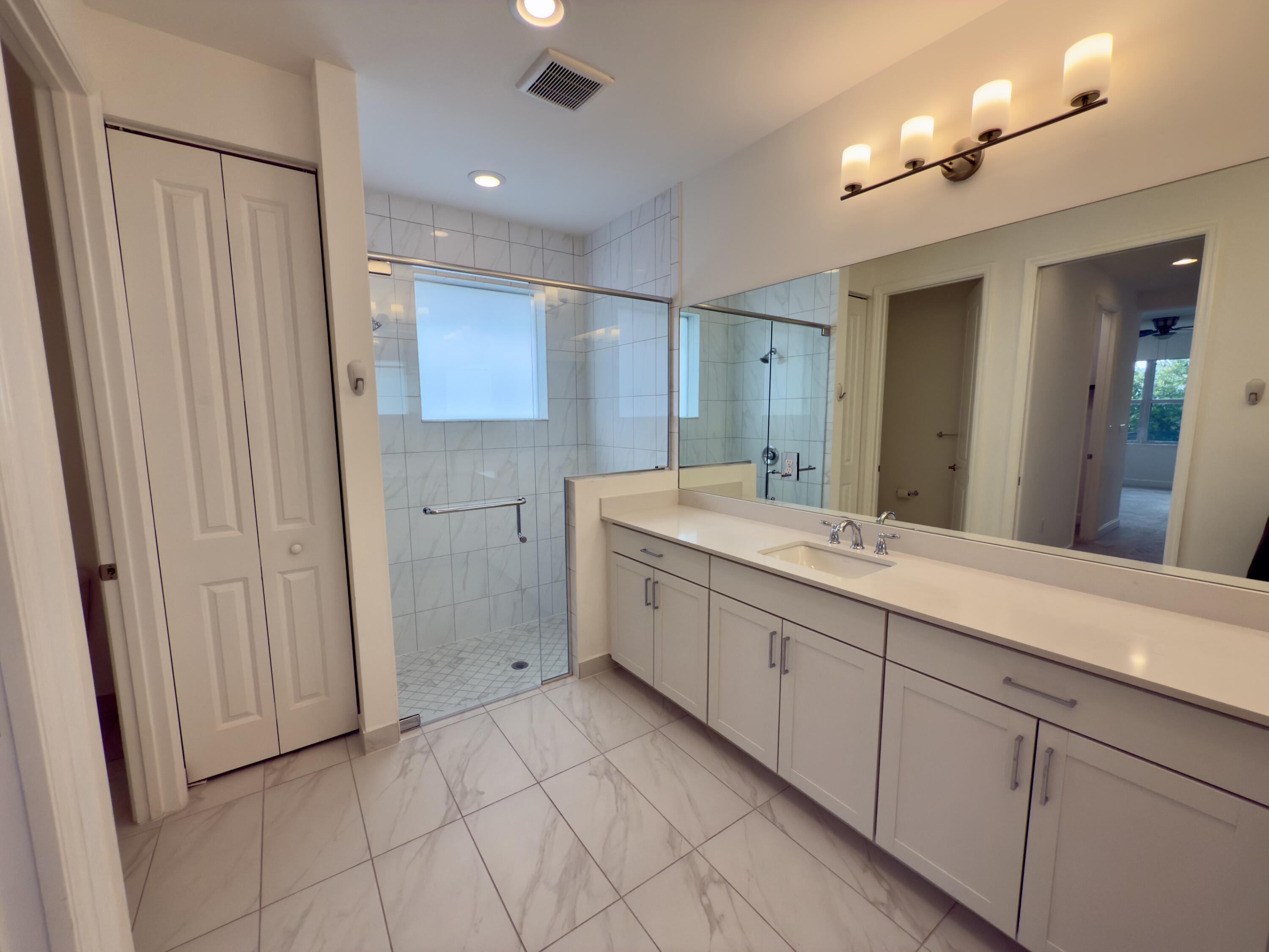 1346 Harvester Crossing Loxahatchee, FL 33470 - Photo 25 of 43 a spacious bathroom with a double vanity sink a mirror and a shower