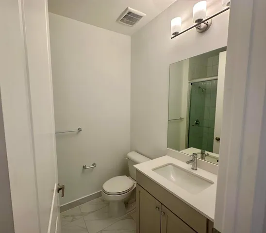a bathroom with a sink a toilet and mirror