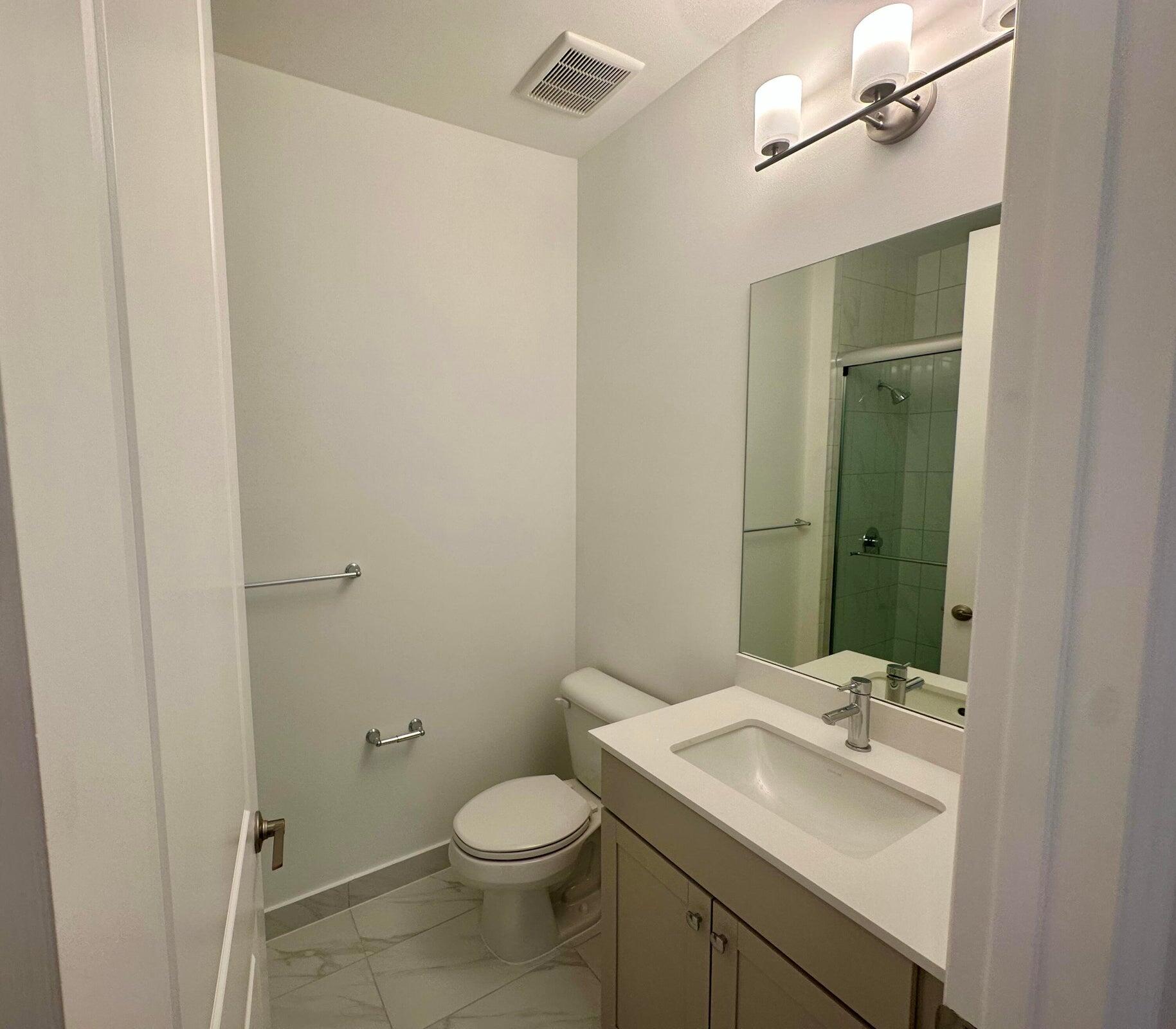 1346 Harvester Crossing Loxahatchee, FL 33470 - Photo 33 of 43 a bathroom with a sink a toilet and mirror