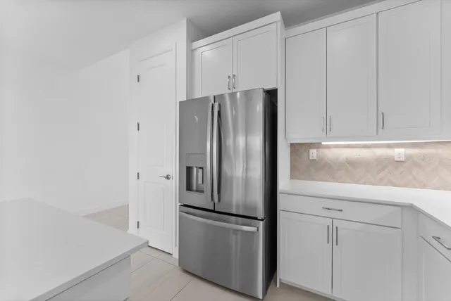 a metallic refrigerator freezer sitting in a kitchen