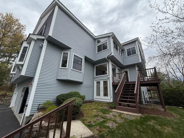 a front view of a house with stairs and wooden fence