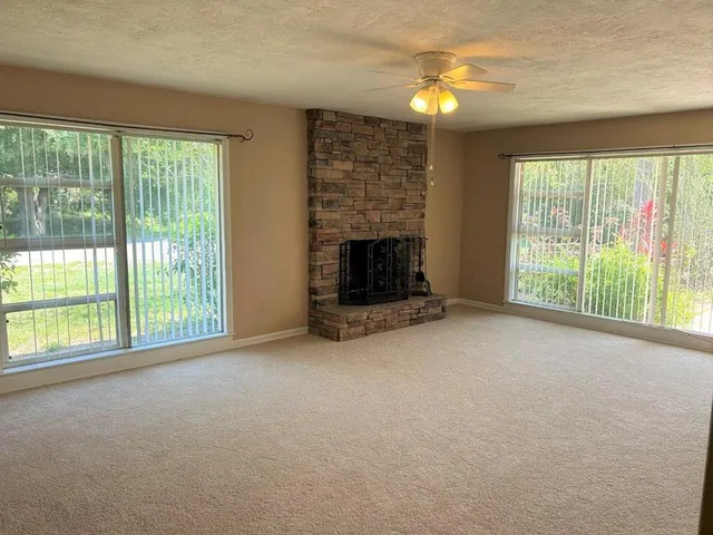 a view of an empty room with window and fire place