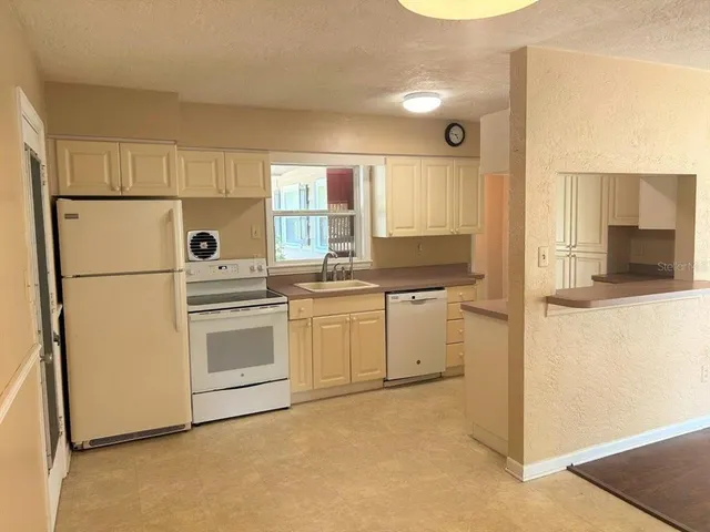 a kitchen with white cabinets and white appliances