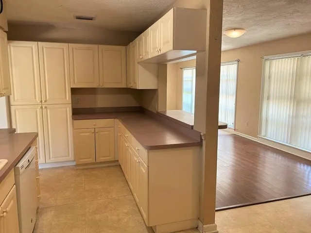 a kitchen with white cabinets and a wooden floor