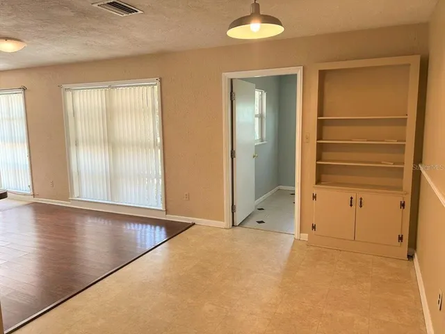 an empty room with window and wooden floor