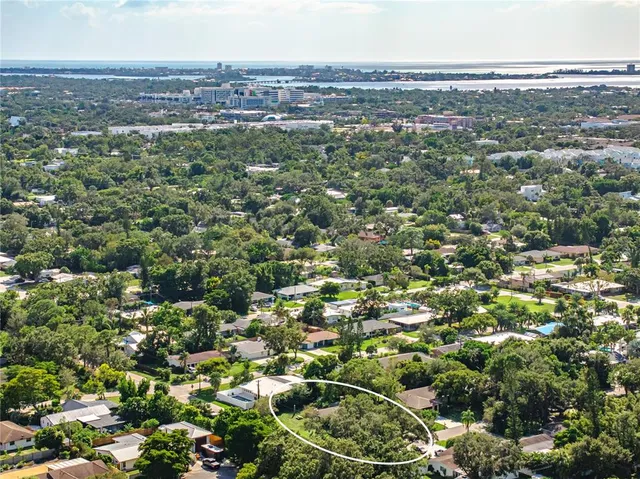 an aerial view of residential houses with outdoor space and trees