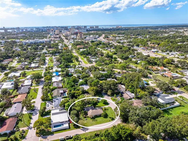 an aerial view of residential houses with outdoor space and trees