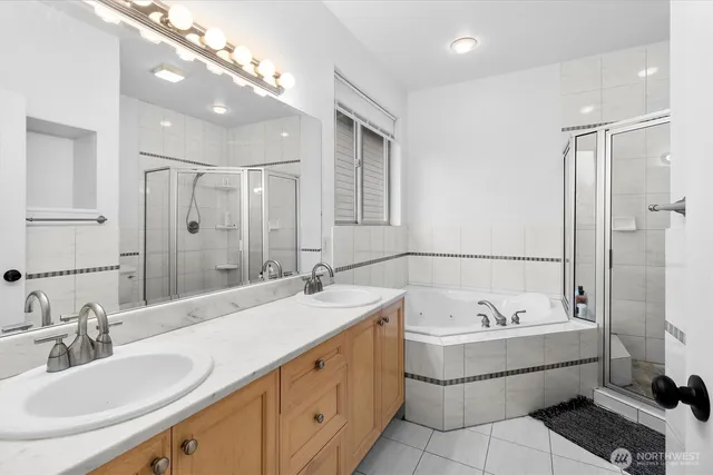 a bathroom with a tub sink shower and mirror