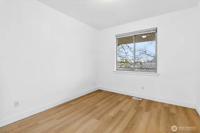 an empty room with a wooden floor and a window