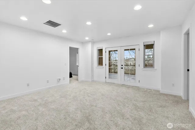 a view of an empty room with glass door and entryway