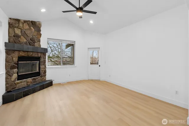 a view of an empty room with window and fireplace
