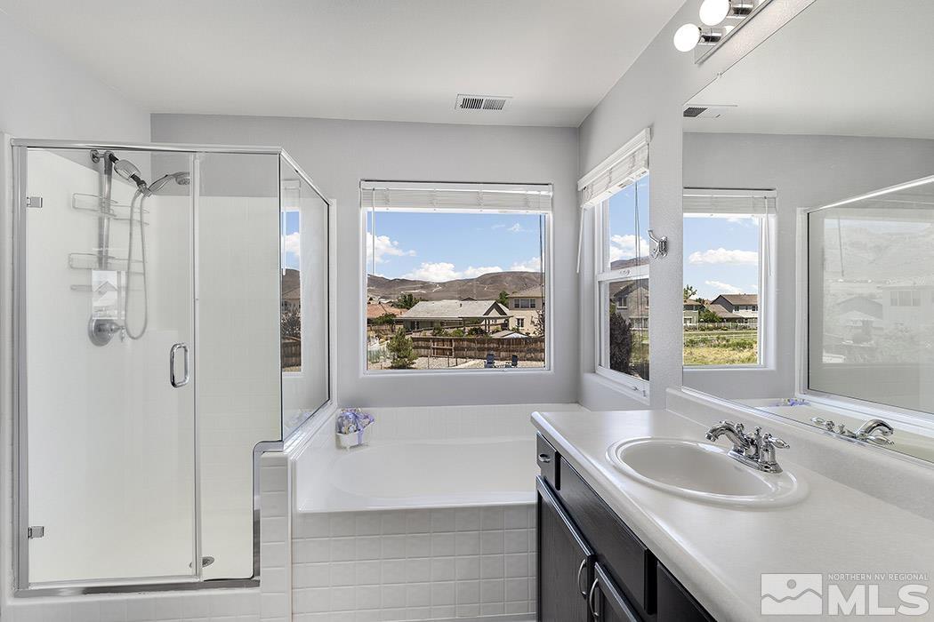 2267 Big Trail Circle Reno, NV 89521 - Photo 24 of 37 a bathroom with a sink double vanity granite tub shower and a mirror