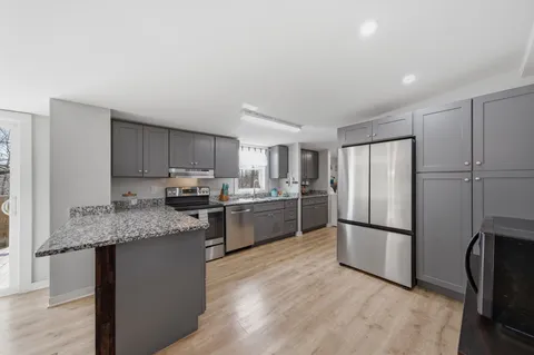 a kitchen with stainless steel appliances granite countertop a refrigerator sink and cabinets