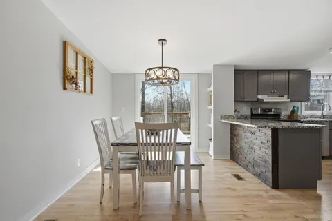 a dining room with furniture a chandelier and wooden floor