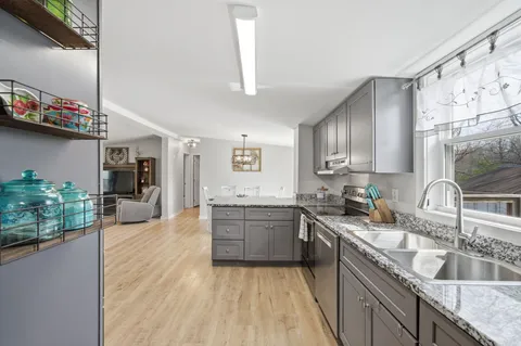 a kitchen with granite countertop a sink stove and cabinets