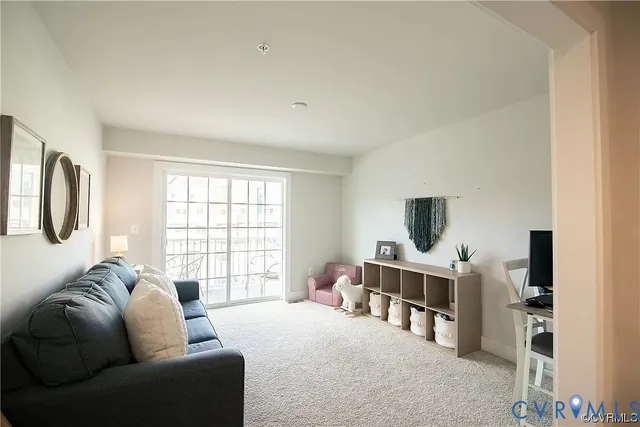a living room with furniture a flat screen tv and a large window